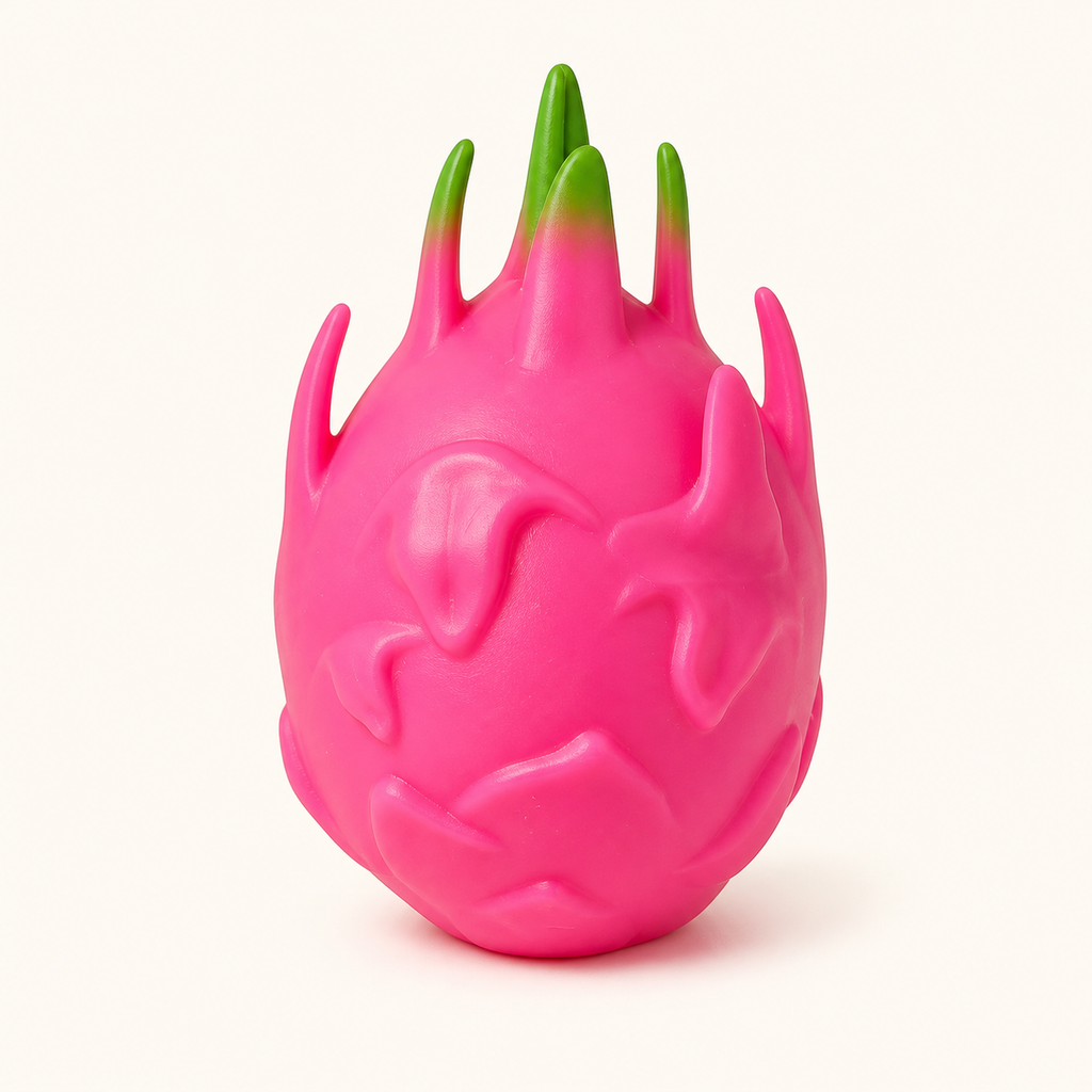Pink dragon fruit squeeze ball with green-tipped fins on a warm white background