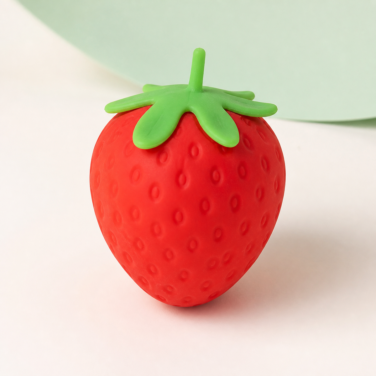 Strawberry Slow-Rise Squishy packshot with red berry texture and green leafy top